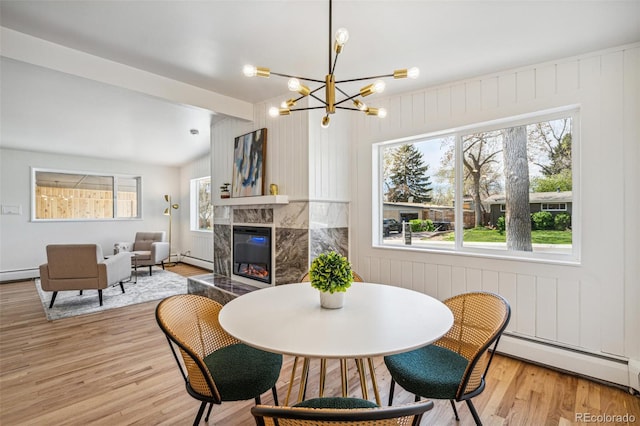 6170 Estes Ct, Arvada, CO 80004 - dining room featuring a healthy amount of sunlight, baseboard heating, a baseboard heating unit, and light wood-style flooring
