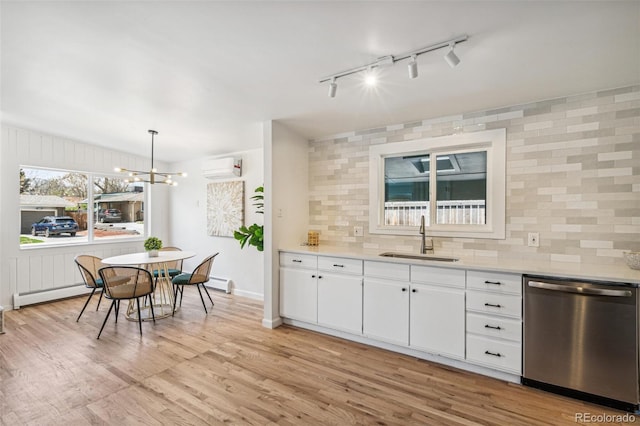 6170 Estes Ct, Arvada, CO 80004 - kitchen with baseboard heating, a sink, a wall unit AC, tasteful backsplash, and stainless steel dishwasher