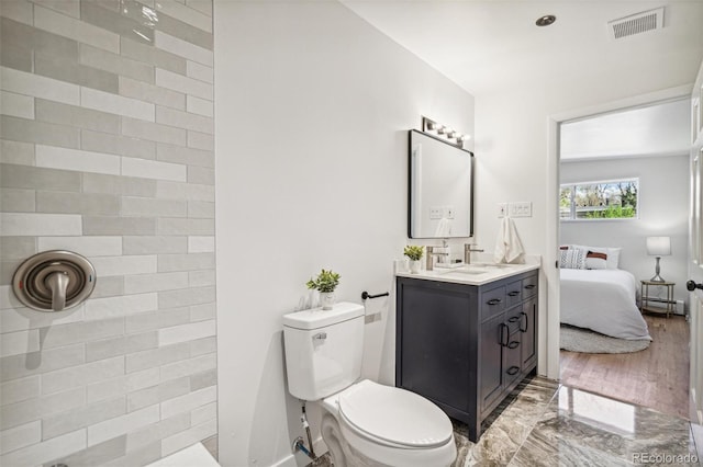 6170 Estes Ct, Arvada, CO 80004 - ensuite bathroom with visible vents, vanity, toilet, a baseboard heating unit, and tiled shower