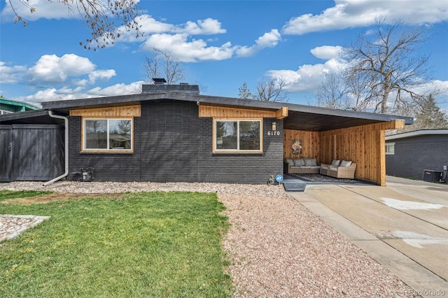 6170 Estes Ct, Arvada, CO 80004 - view of front of home featuring a carport, central AC, brick siding, and a front yard