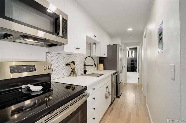 336 N Grant St Unit 206, Denver, CO 80203 - kitchen with a sink, decorative backsplash, stainless steel appliances, and white cabinetry