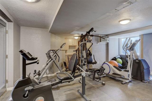 336 N Grant St Unit 206, Denver, CO 80203 - exercise area featuring a textured ceiling, a wall unit AC, and baseboards