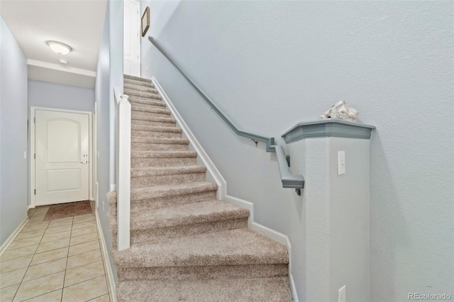 stairway with tile patterned floors and baseboards