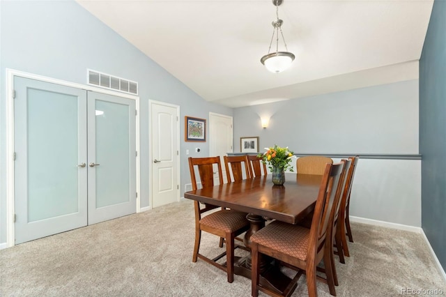 dining room with visible vents, baseboards, high vaulted ceiling, french doors, and light colored carpet