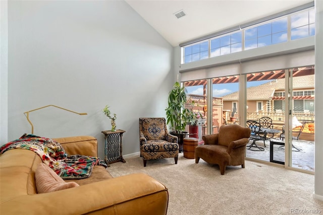 interior space featuring baseboards, visible vents, and high vaulted ceiling