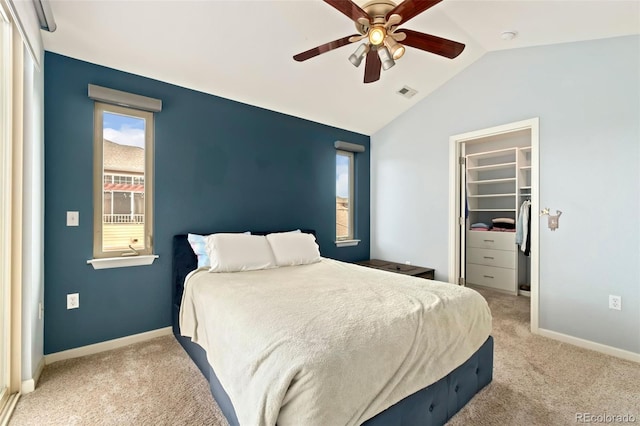 bedroom featuring a spacious closet, visible vents, carpet, and lofted ceiling