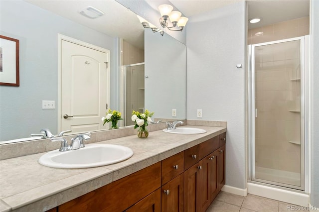 full bathroom featuring tile patterned floors, a shower stall, double vanity, and a sink