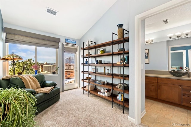 living area featuring lofted ceiling, visible vents, and light carpet