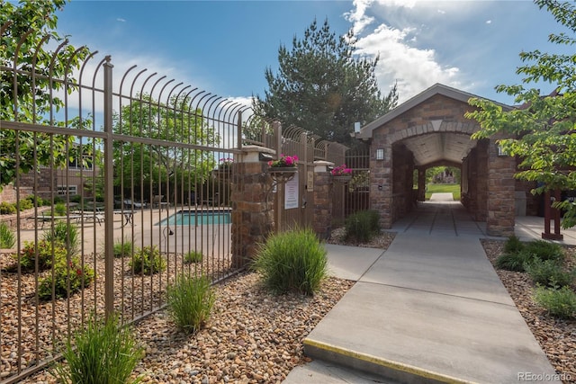 exterior space featuring a gate, a swimming pool, and fence