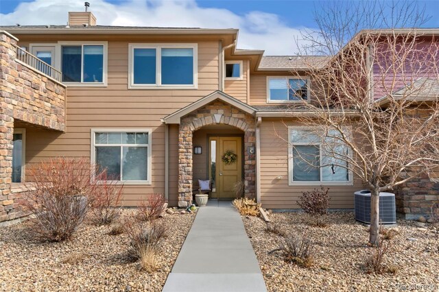 view of front of house with stone siding and central AC