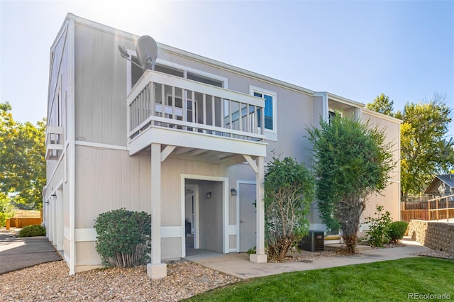 rear view of property with a balcony and central AC