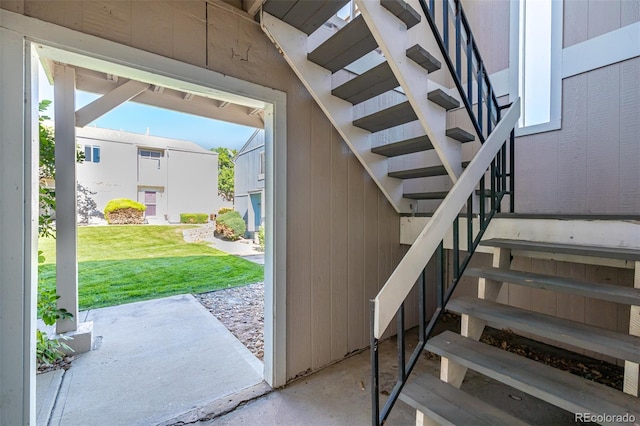 staircase with wood walls and concrete flooring