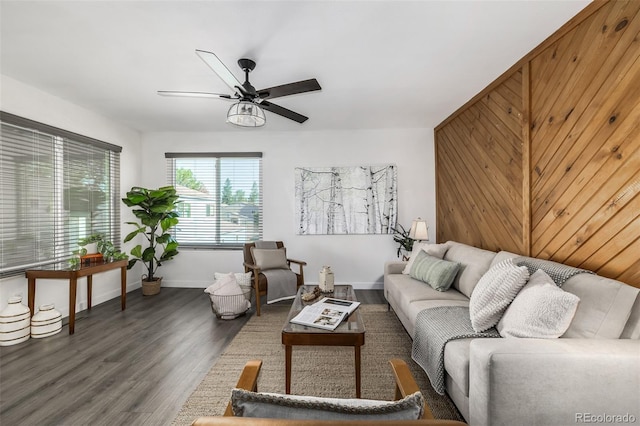 living room featuring wooden walls, dark hardwood / wood-style flooring, and ceiling fan