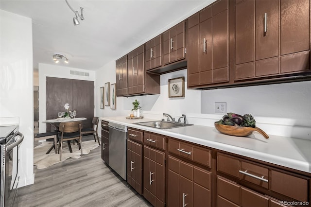 kitchen with light hardwood / wood-style flooring, stainless steel appliances, dark brown cabinetry, and sink