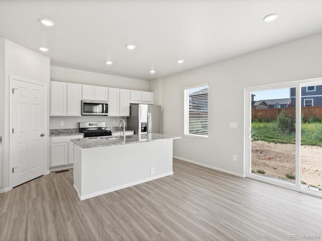 1134 Thunder Pass Rd, Severance, CO 80550 - kitchen featuring appliances with stainless steel finishes, light wood-type flooring, a center island with sink, plenty of natural light, and recessed lighting