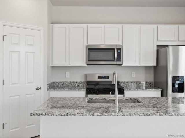 1134 Thunder Pass Rd, Severance, CO 80550 - kitchen with stainless steel appliances, white cabinetry, and light stone counters