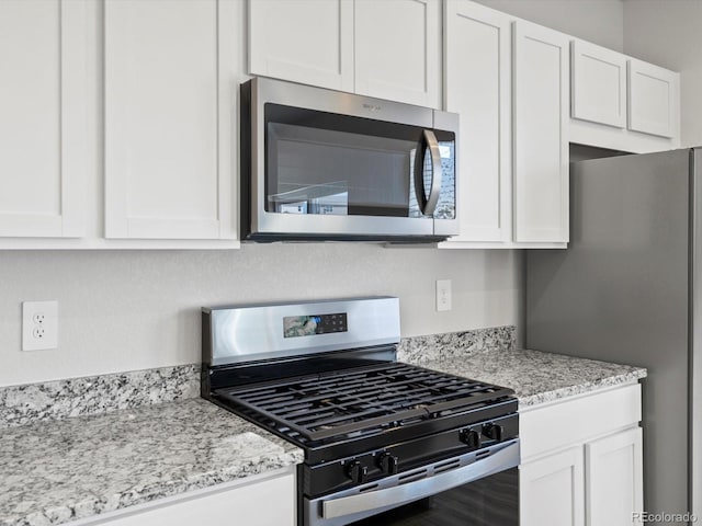 1134 Thunder Pass Rd, Severance, CO 80550 - kitchen with stainless steel appliances, white cabinetry, and light stone counters
