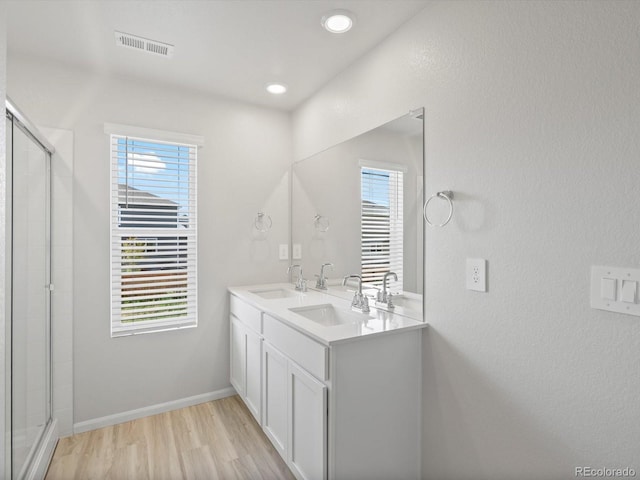 1134 Thunder Pass Rd, Severance, CO 80550 - full bathroom with double vanity, wood finished floors, plenty of natural light, tiled shower, and recessed lighting