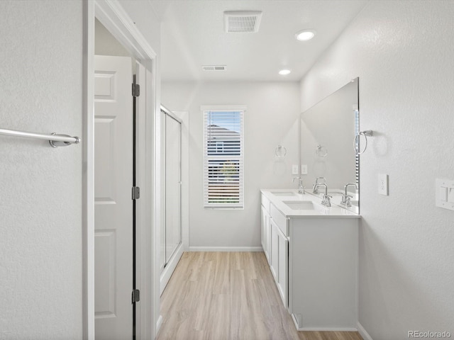 1134 Thunder Pass Rd, Severance, CO 80550 - bathroom with a shower stall, wood finished floors, double vanity, and a textured wall