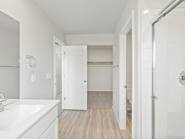 1134 Thunder Pass Rd, Severance, CO 80550 - full bathroom featuring wood finished floors, a stall shower, vanity, and a spacious closet