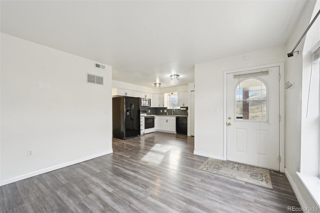 interior space featuring a wealth of natural light, visible vents, and dark wood finished floors