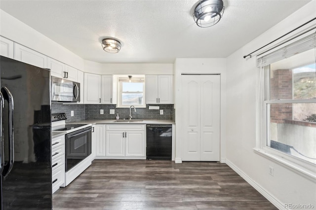 kitchen with tasteful backsplash, light countertops, white cabinets, black appliances, and a sink