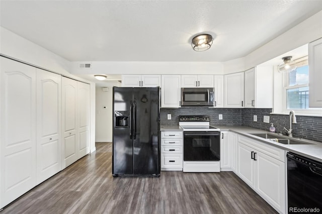 kitchen with a sink, tasteful backsplash, black appliances, and dark wood finished floors