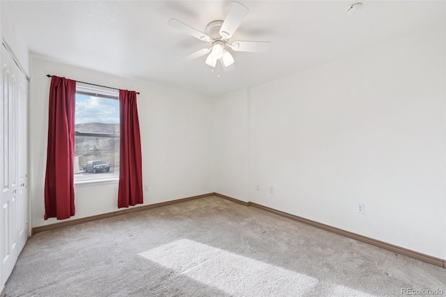 carpeted empty room with baseboards and ceiling fan