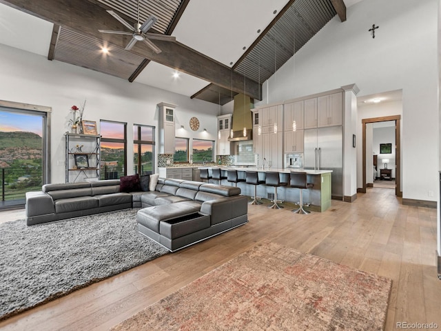 12947 Lazy Dog Ln, Littleton, CO 80127 - living room featuring high vaulted ceiling, beam ceiling, light wood-style flooring, and a ceiling fan