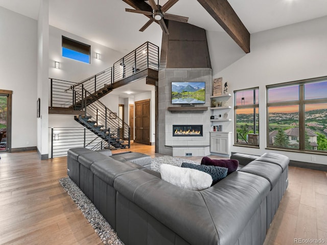 12947 Lazy Dog Ln, Littleton, CO 80127 - living area with high vaulted ceiling, a ceiling fan, beam ceiling, stairs, and wood finished floors