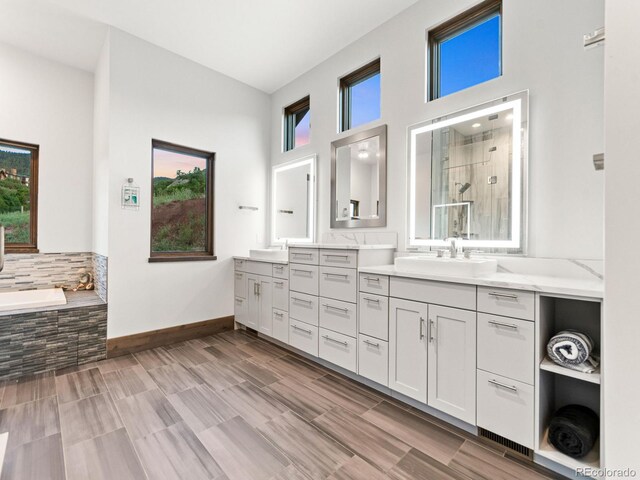 12947 Lazy Dog Ln, Littleton, CO 80127 - full bathroom featuring double vanity, tiled shower, and a garden tub