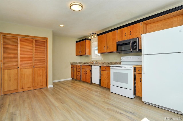 620 James Pl, Buena Vista, CO 81211 - kitchen with white appliances, light wood-type flooring, brown cabinetry, recessed lighting, and light countertops