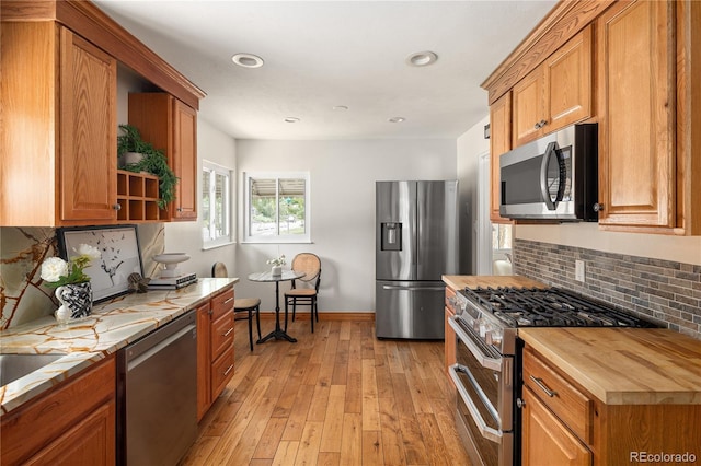 2680 S Garfield Cir, Denver, CO 80210 - kitchen with stainless steel appliances, butcher block countertops, open shelves, backsplash, and brown cabinets