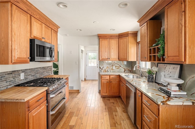 2680 S Garfield Cir, Denver, CO 80210 - kitchen with appliances with stainless steel finishes, open shelves, decorative backsplash, light wood-style flooring, and recessed lighting