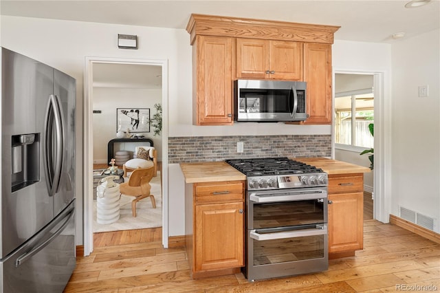 2680 S Garfield Cir, Denver, CO 80210 - kitchen featuring stainless steel appliances, butcher block counters, light wood finished floors, and tasteful backsplash