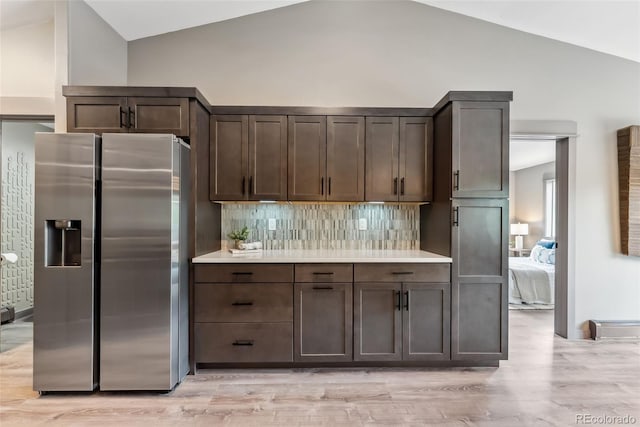 143 Brady Rd, Buena Vista, CO 81211 - kitchen featuring stainless steel fridge with ice dispenser, vaulted ceiling, dark brown cabinetry, and light wood-type flooring