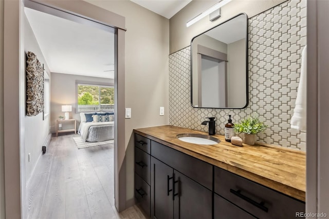 143 Brady Rd, Buena Vista, CO 81211 - bathroom featuring decorative backsplash, wood finished floors, vanity, and baseboards