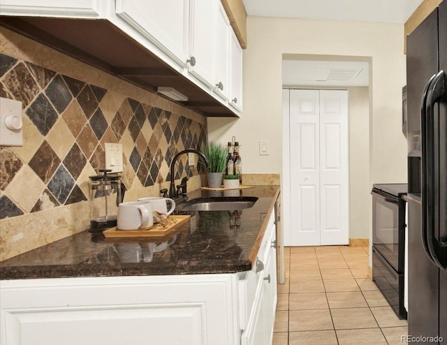 7755 E Quincy Ave Unit 206, Denver, CO 80237 - kitchen featuring black range with electric cooktop, white cabinets, decorative backsplash, light tile patterned floors, and dark stone countertops