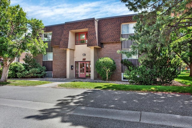 7755 E Quincy Ave Unit 206, Denver, CO 80237 - view of front of house with brick siding, mansard roof, a shingled roof, and french doors