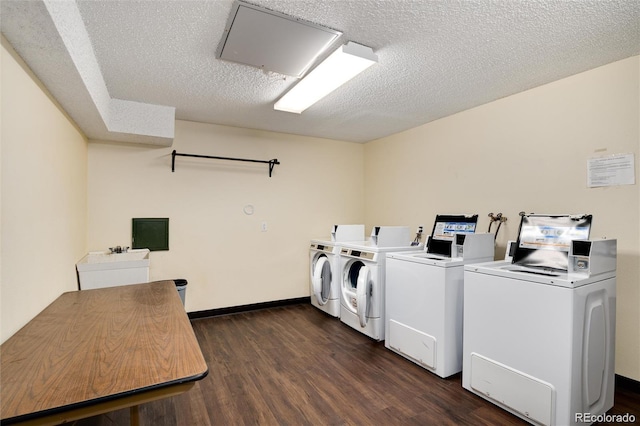 laundry area with dark hardwood / wood-style flooring, sink, a textured ceiling, and washer and clothes dryer