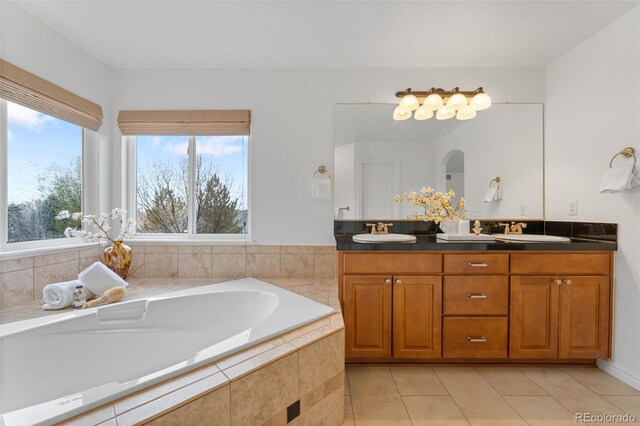 full bath featuring tile patterned floors, a garden tub, and double vanity