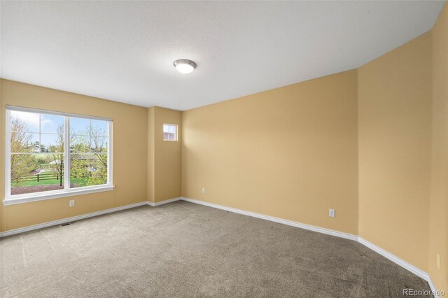spare room with carpet flooring and baseboards