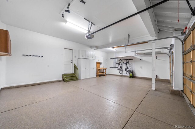 garage featuring a garage door opener and baseboards