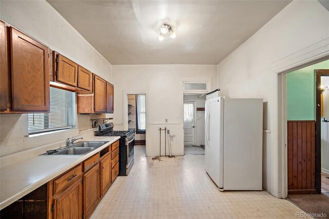 117 S Limit St, Colorado Springs, CO 80905 - kitchen with freestanding refrigerator, gas stove, a sink, brown cabinetry, and light floors