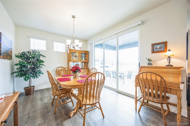 dining space featuring a notable chandelier, dark wood-type flooring, and a healthy amount of sunlight