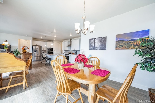 dining room featuring a notable chandelier, sink, and light wood-type flooring