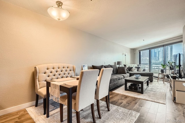 dining area featuring wood-type flooring and a textured ceiling