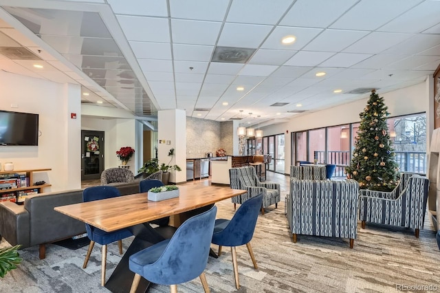 carpeted dining room featuring a paneled ceiling