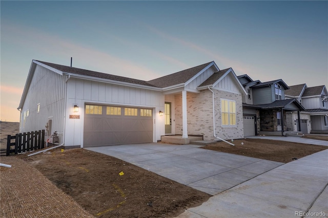 view of front of house with board and batten siding, brick siding, driveway, and an attached garage