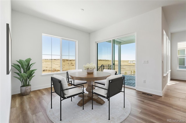 dining space featuring a wealth of natural light, baseboards, and wood finished floors